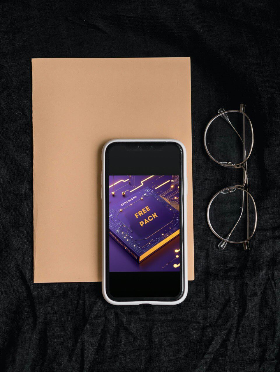 Phone with 'Free Pack' course interface, glasses, and notebook on a black background